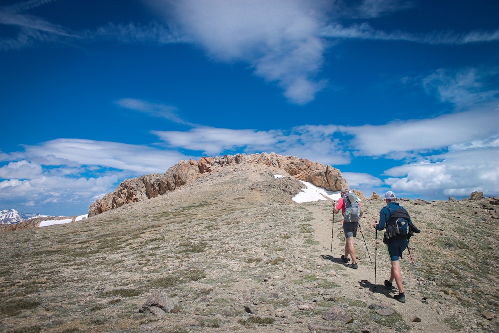 two person standing near mountain during daytime