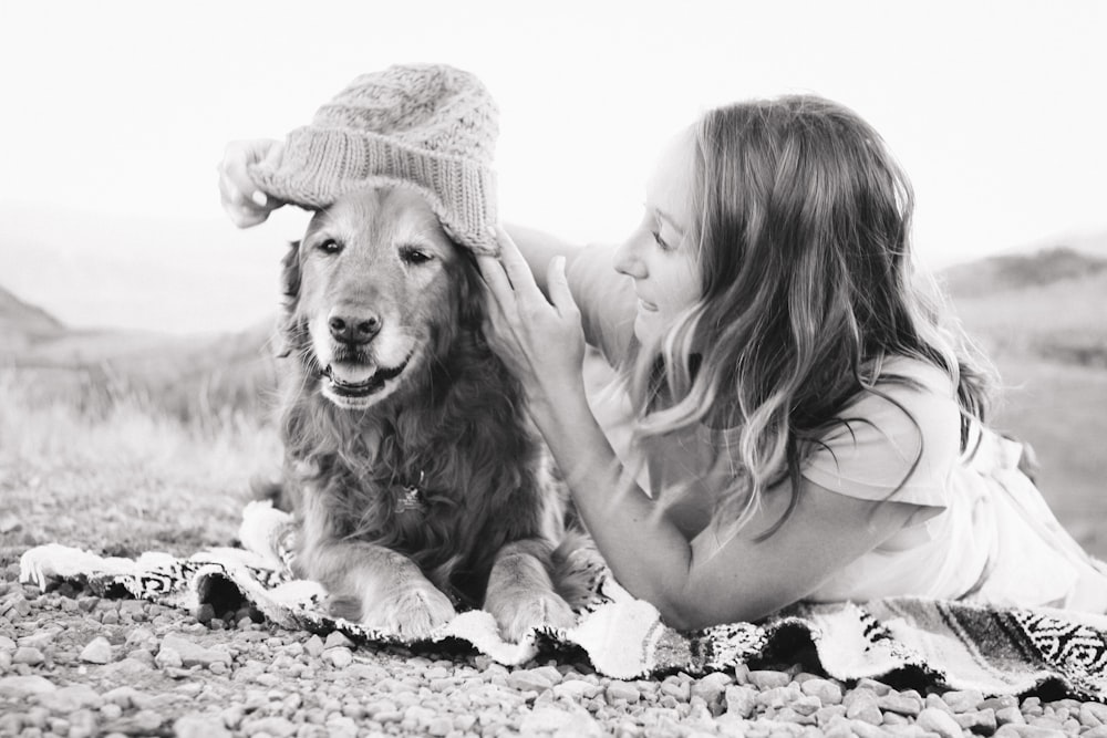 person lying on gray textile beside dog near outdoor