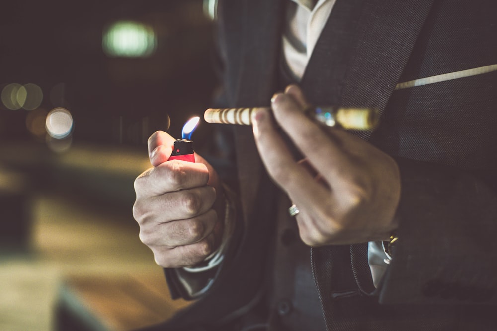 a man in a suit holding a lighter in his hand