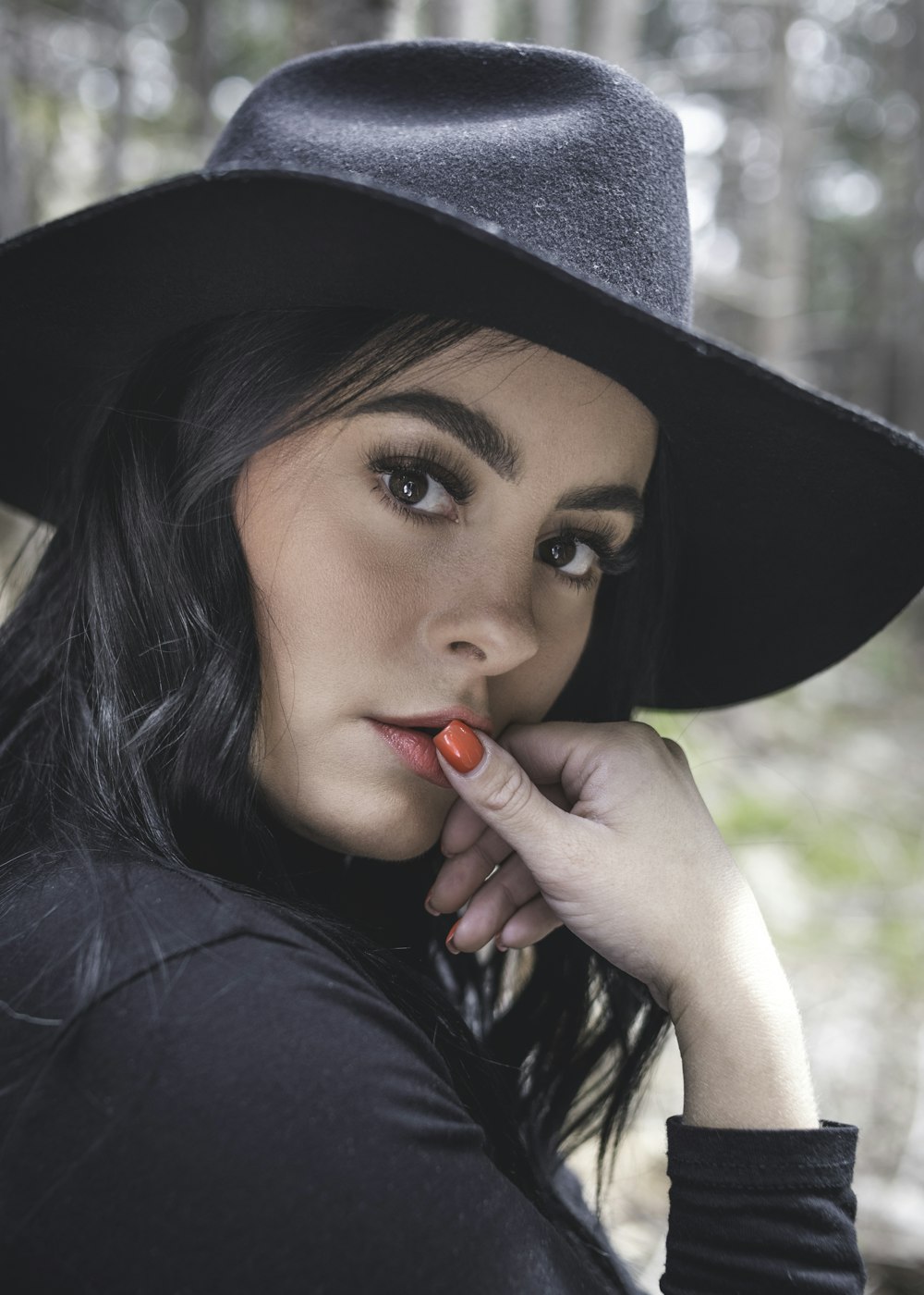 a woman wearing a black hat and a black shirt