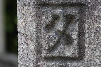 Close-up of a stone tile engraved with a custom logo and fine details.