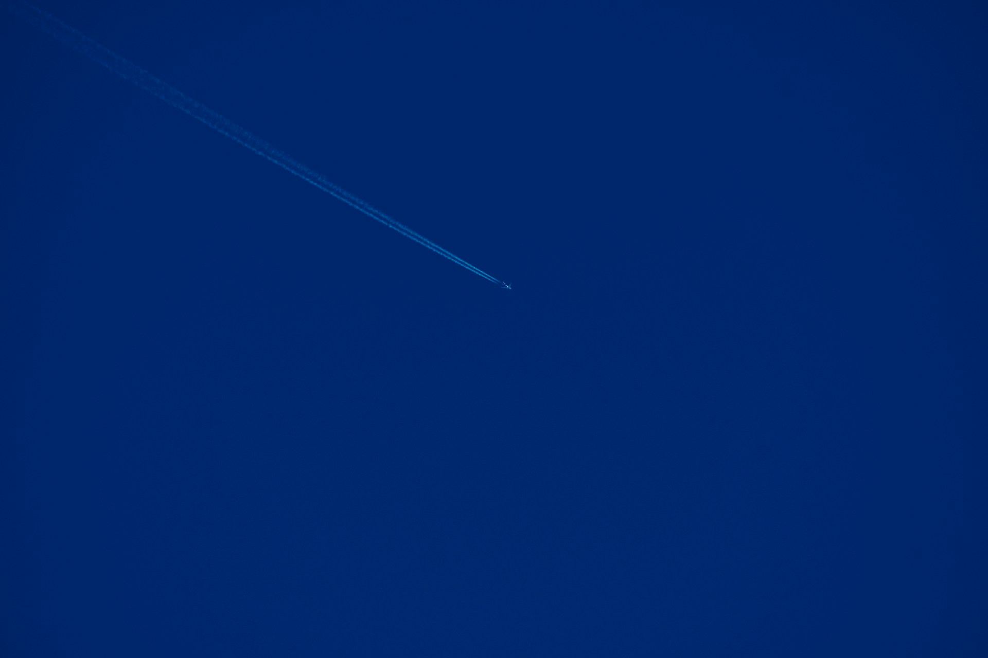 an airplane is flying in the blue sky