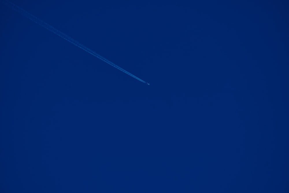 an airplane is flying in the blue sky