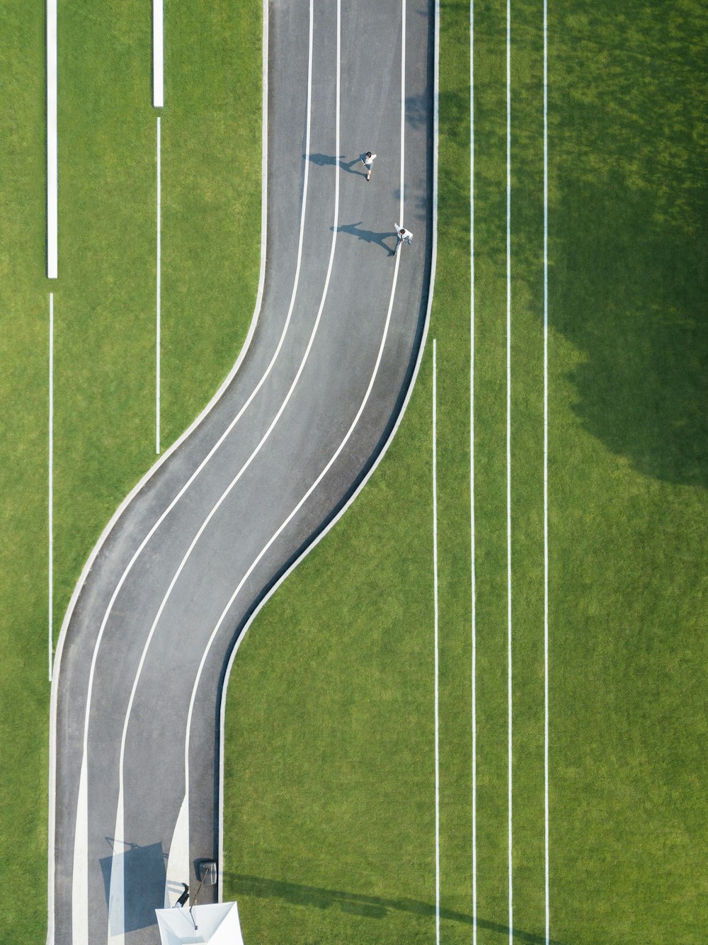 aerial photography of two person running on road during daytime
