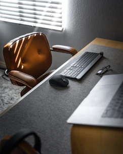A sleek executive office setup featuring natural wood desks and ergonomic chairs bathed in warm light.