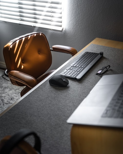 An office desk with a keyboard, monitor, and paperwork set up for data entry work