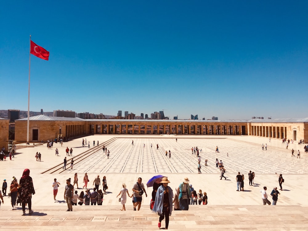 people walking near waving flag