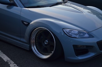 Close-up of new tires and car decorations installed on a sleek blue sedan.