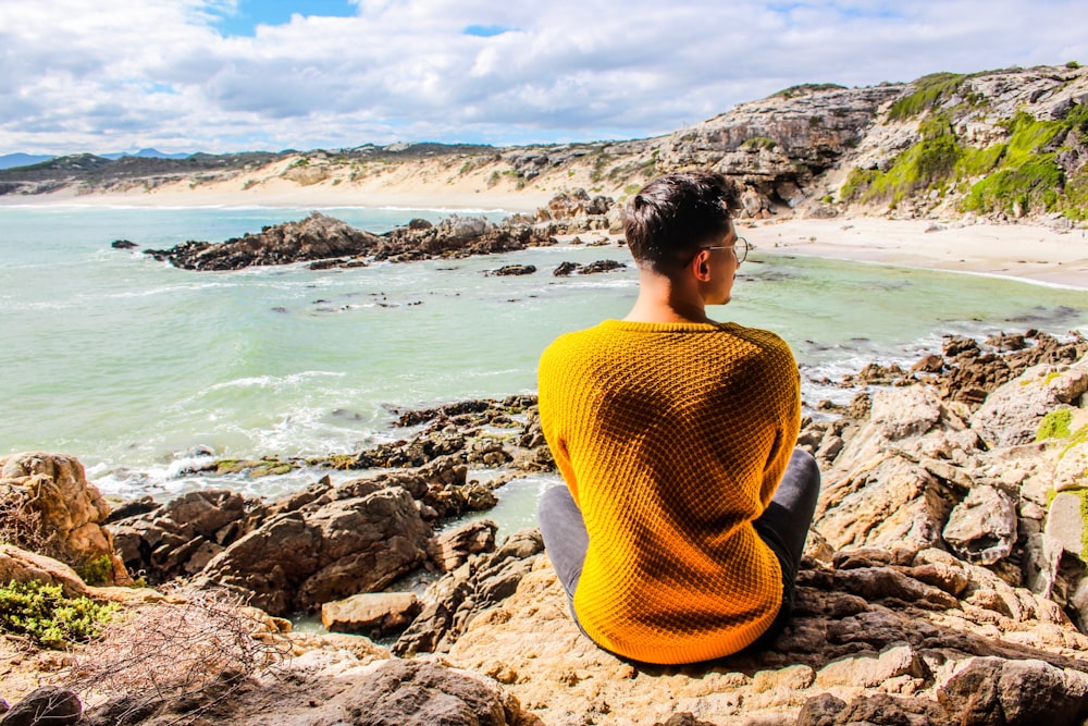 man sitting on rock