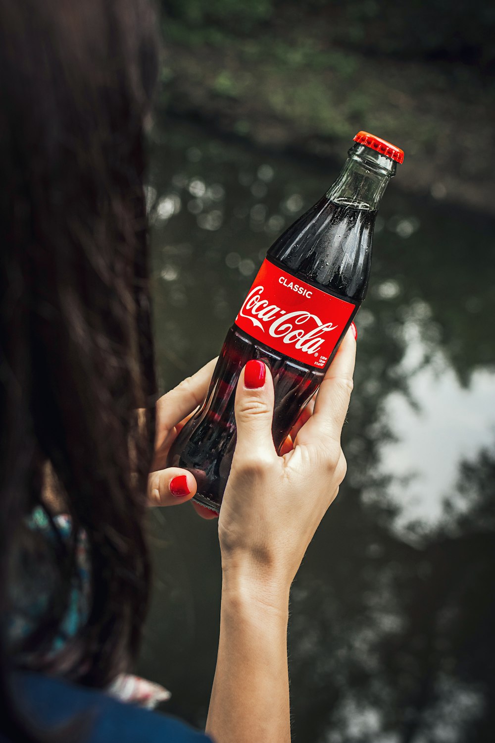 women holding a red Coca-Cola bottle during daytime