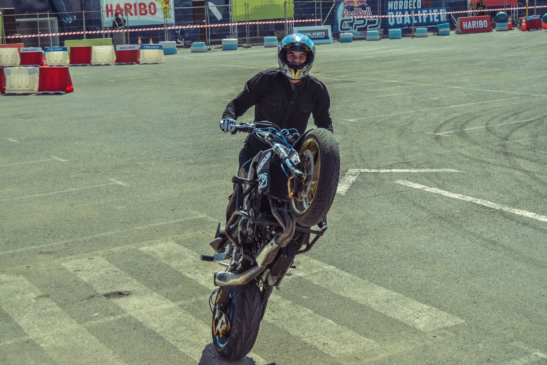 man doing wheelie on black street bike