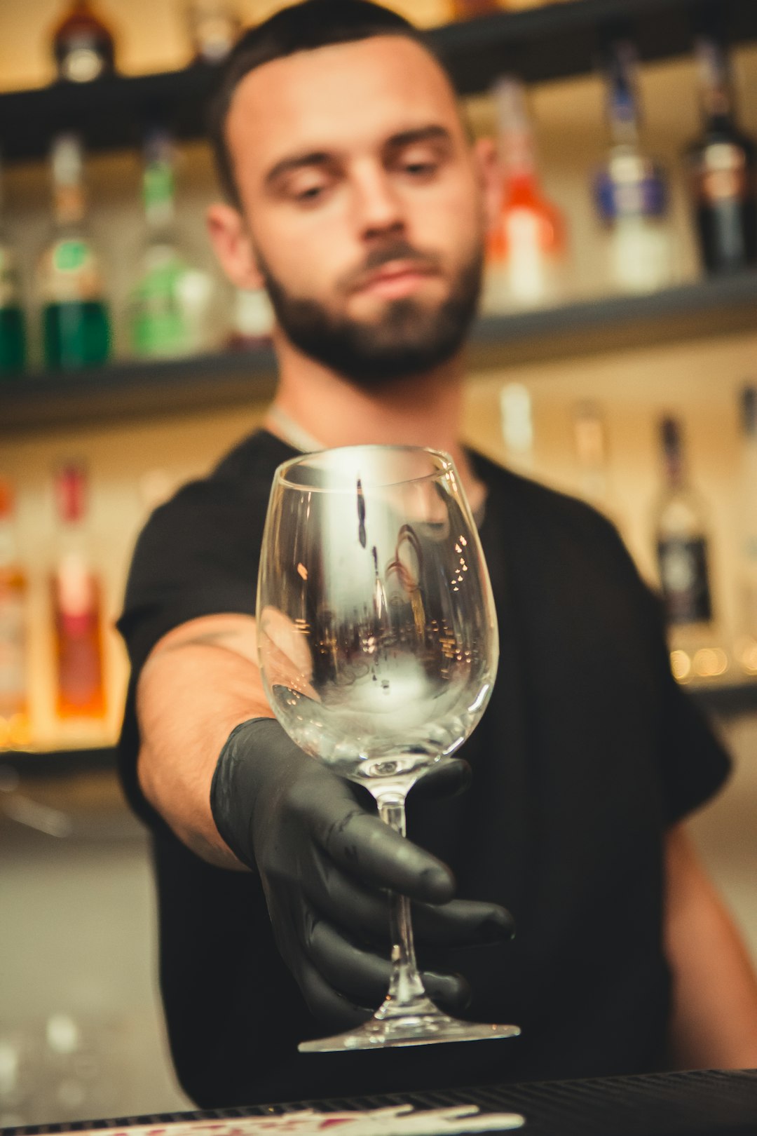 man holding empty clear glass wine goblet