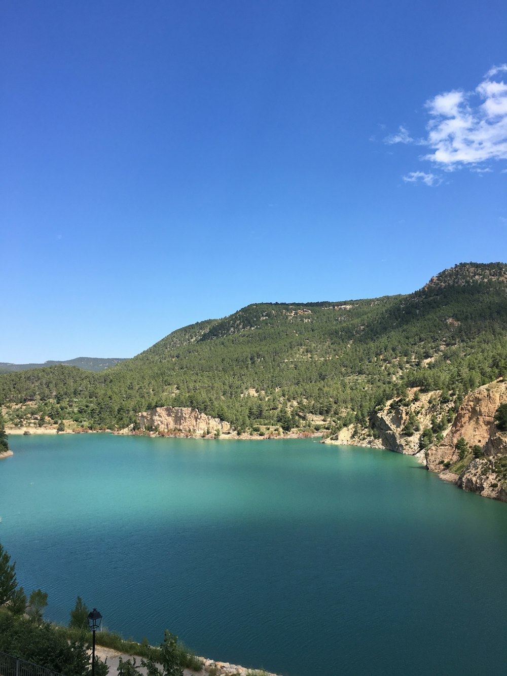 body of water near mountain at daytime