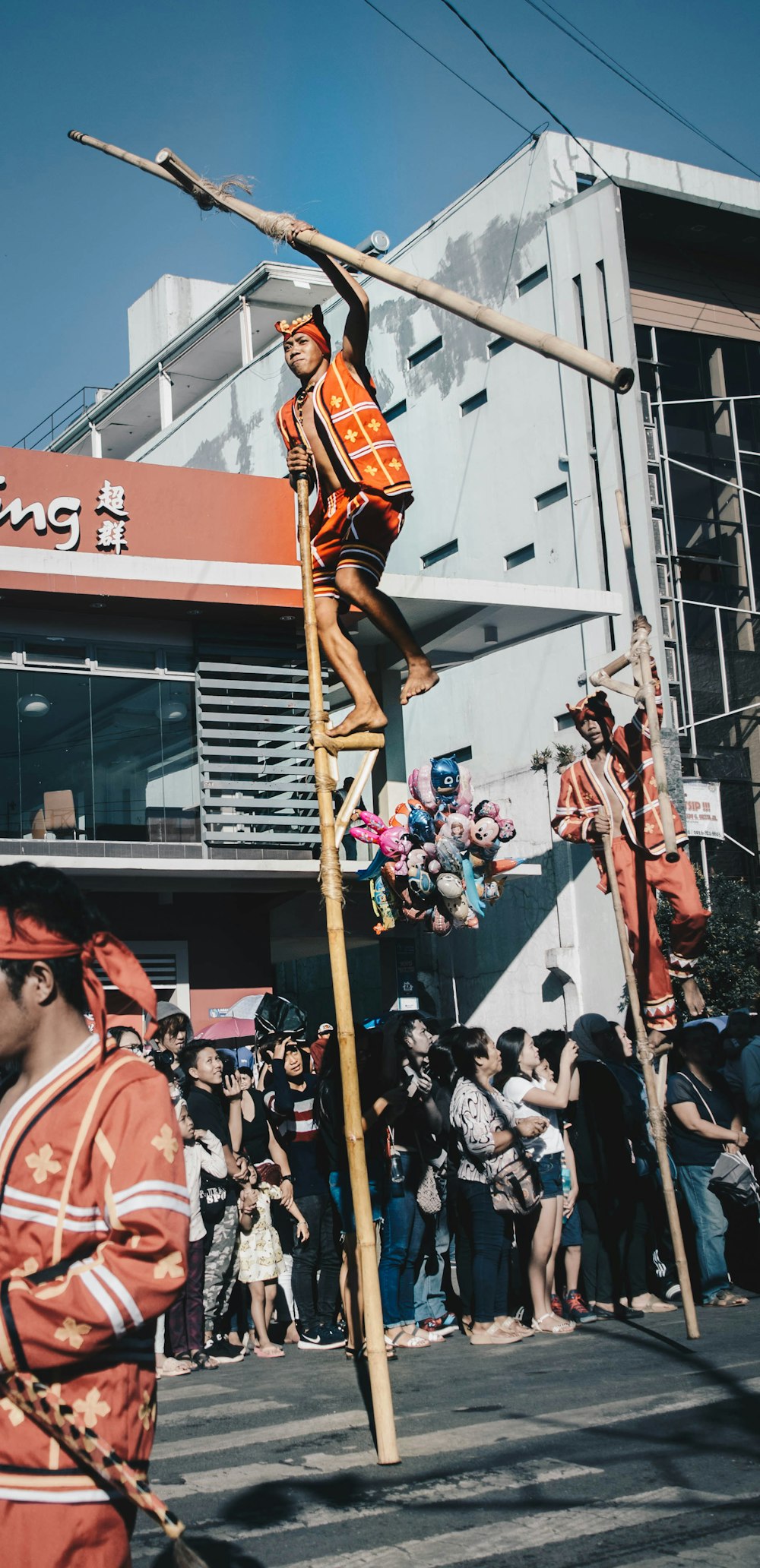 man in orange outfit standing on pole