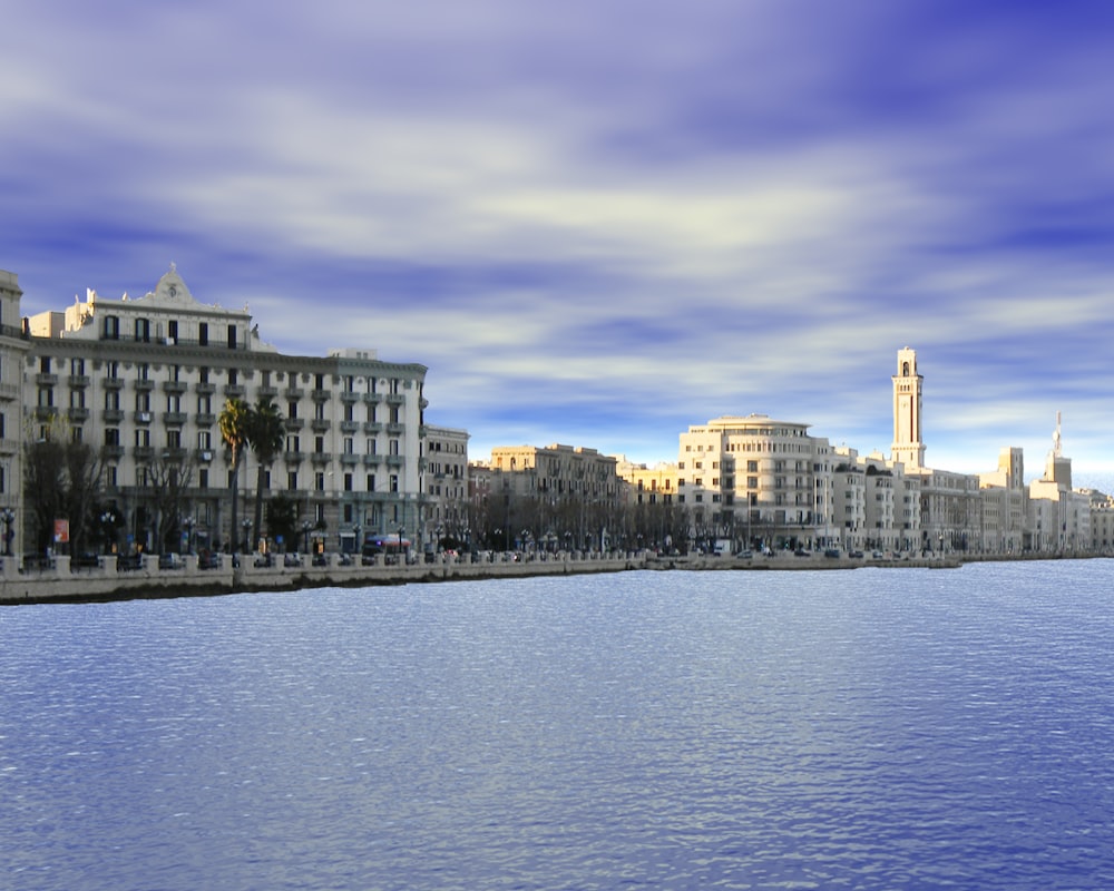 edificio in cemento bianco vicino a uno specchio d'acqua