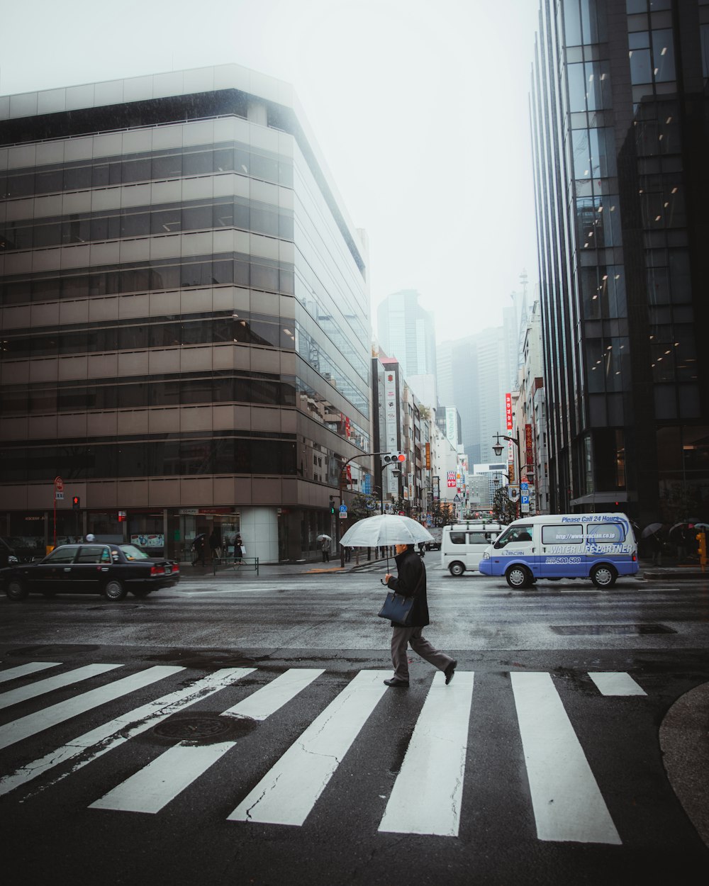 Person mit Regenschirm geht auf Fußgänger