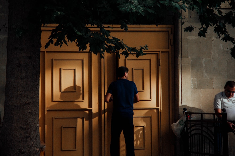 茶色の木製のドアのそばに立っている見知らぬ人物