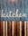 A stylized wooden sign spelling out the word 'kitchen' is mounted on a vertically striped background. The top half of the image features a blue and white striped pattern, while the lower half consists of alternating wooden planks in various shades of brown. The design combines a rustic and modern aesthetic.