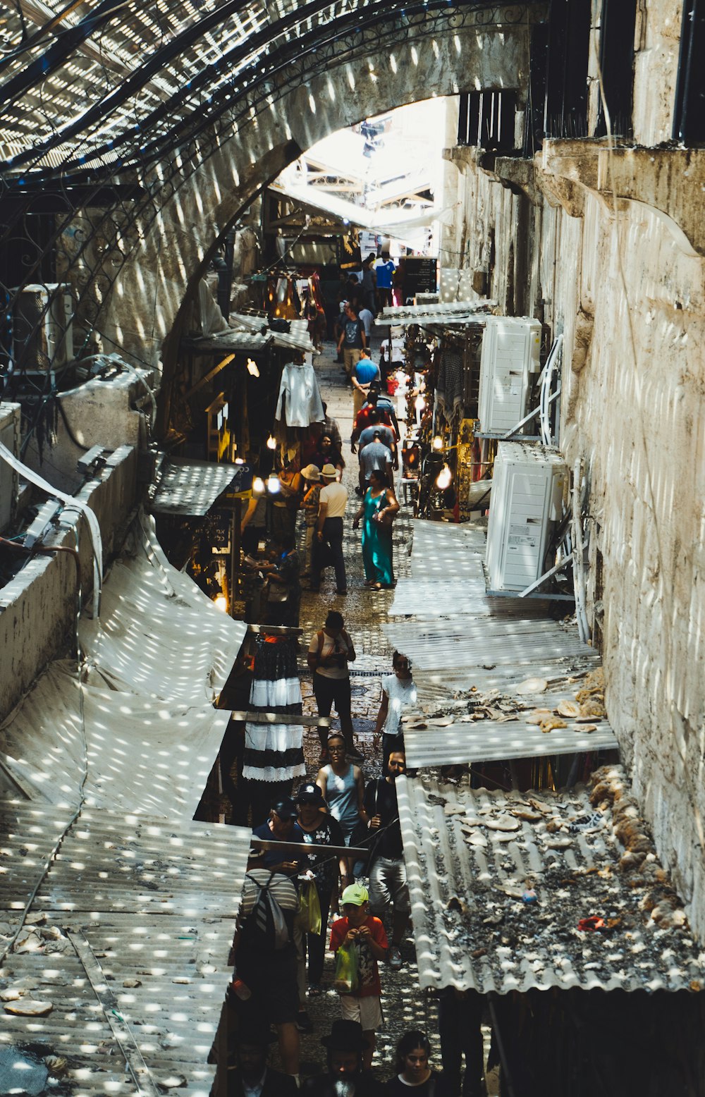 a group of people walking down a street under a bridge