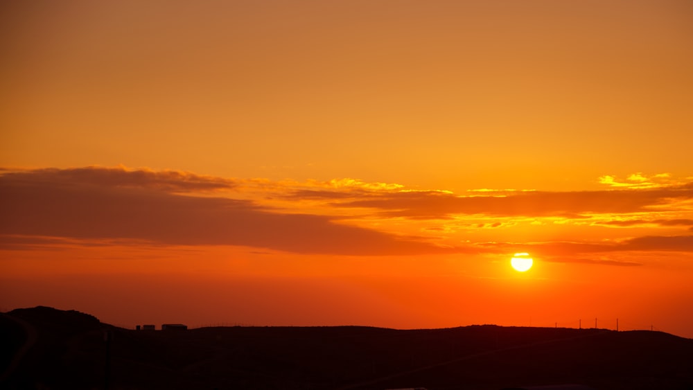 silhouette of mountain under orange skies