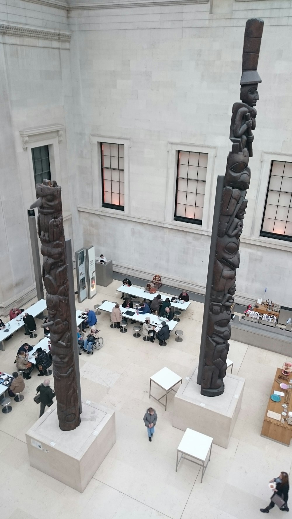 people sitting and others are standing near table inside building