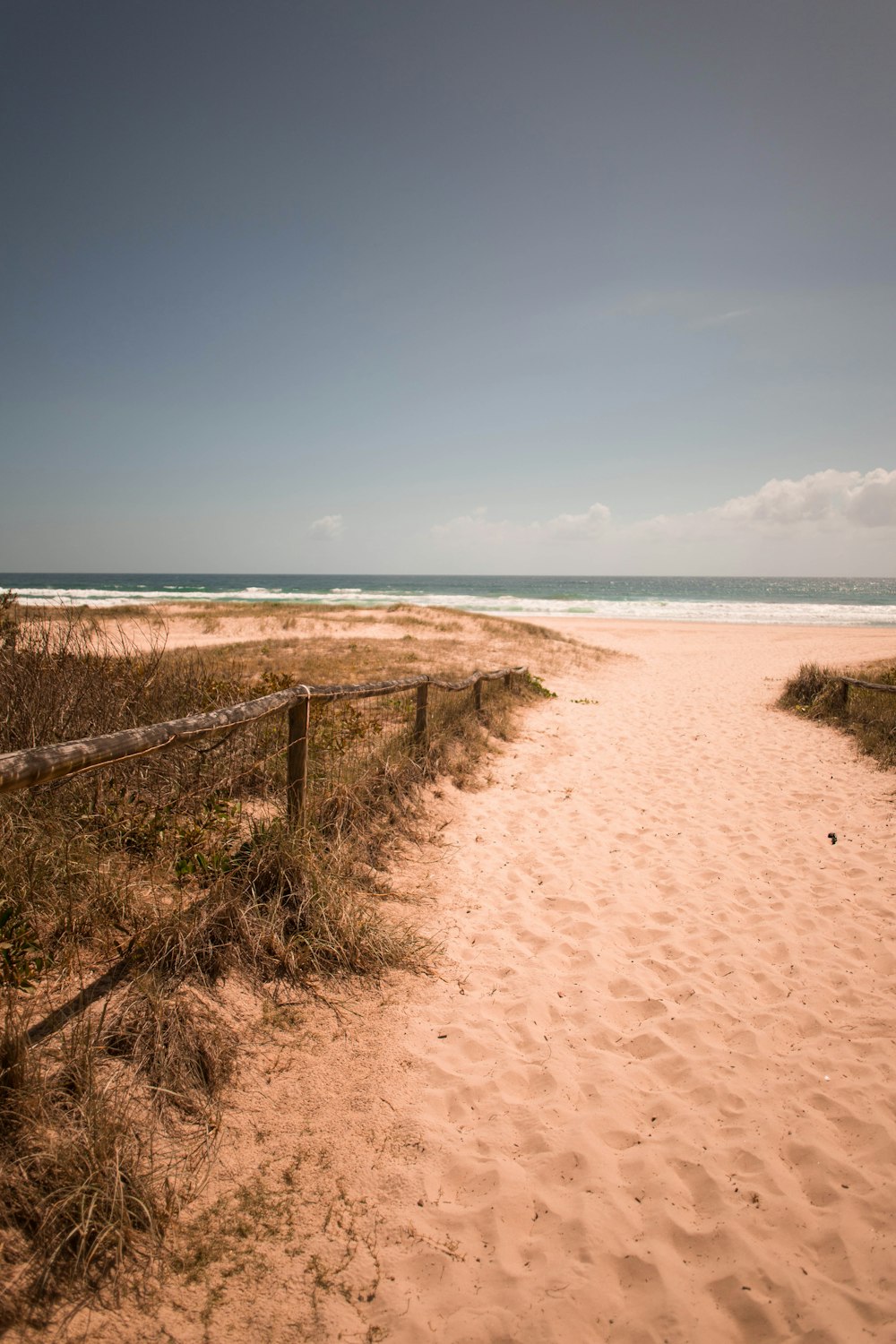 wooden fence in seashore under blue sky