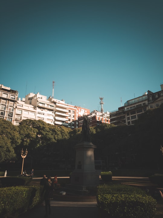 trees beside concrete buildings in Plaza Libertad Argentina