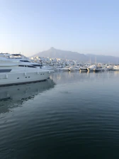 A serene early morning view of a luxury boat gently anchored in the calm waters of La Spezia’s harbor.