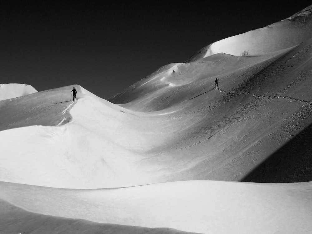 two people skiing down a snow covered mountain