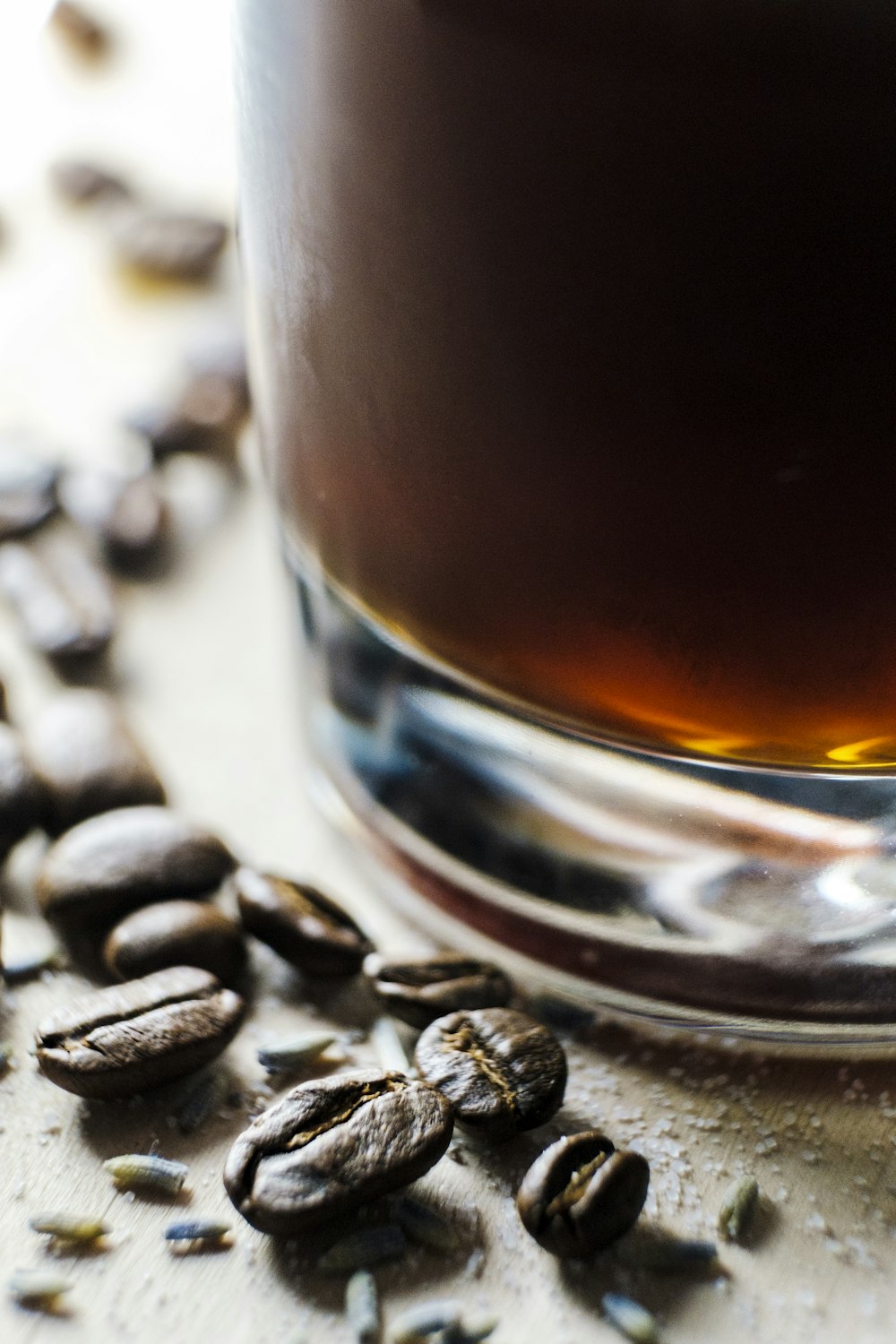 coffee beans beside glass container filled with brown liquid