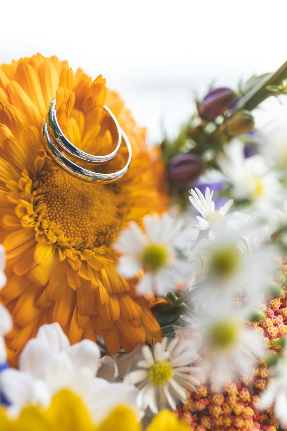 a wedding ring sitting on a bouquet of flowers