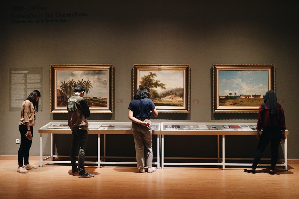 people standing in front of paintings