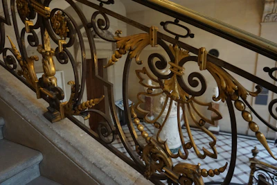 Intricate iron railing with detailed scrollwork on a staircase.