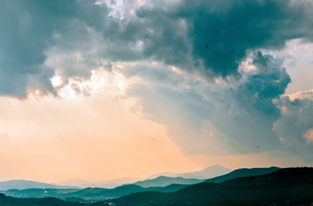 silhouette of mountains under white clouds