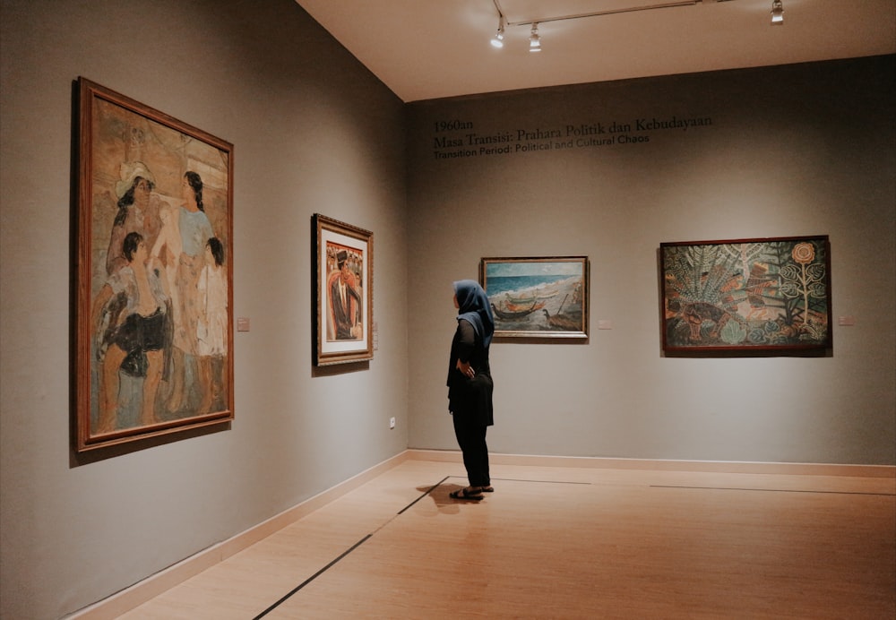 woman standing in front of paintings