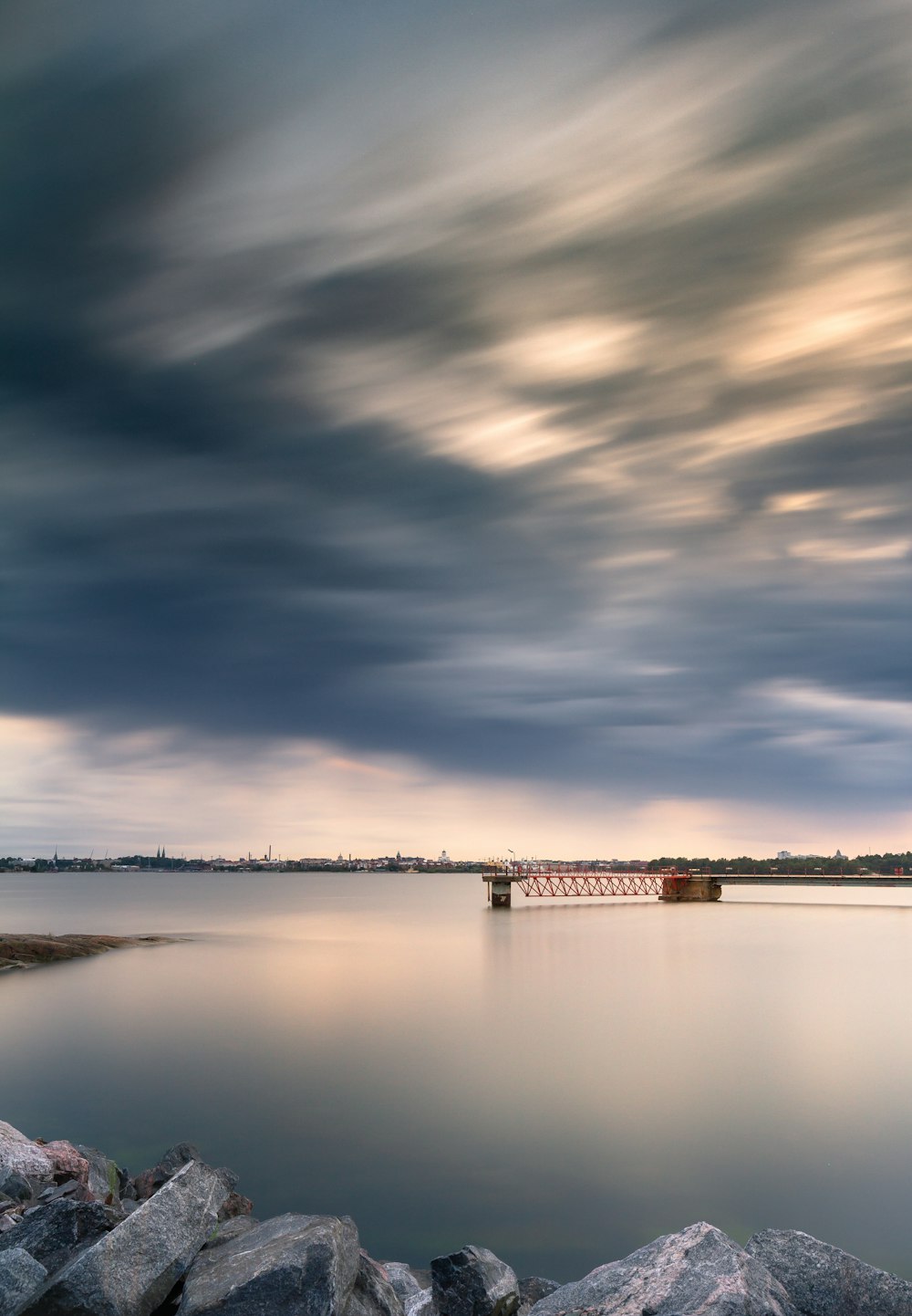 a body of water surrounded by rocks under a cloudy sky