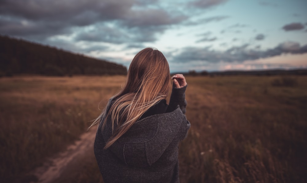 close-up photography of woman standing near grass field