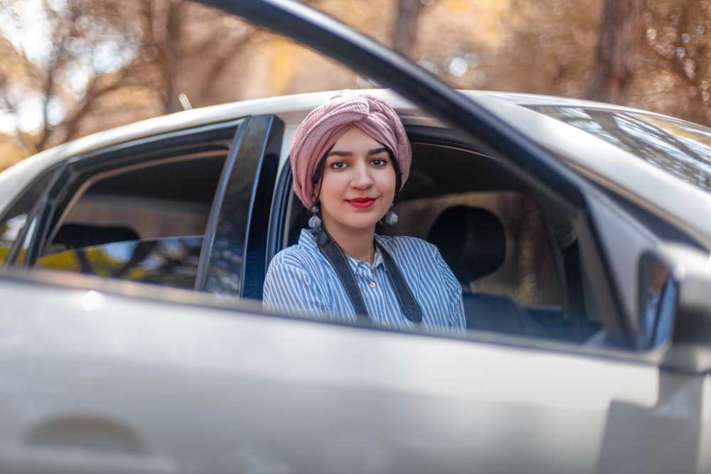 a woman with a pink turban sitting in a car