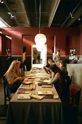 women sitting at table reading books