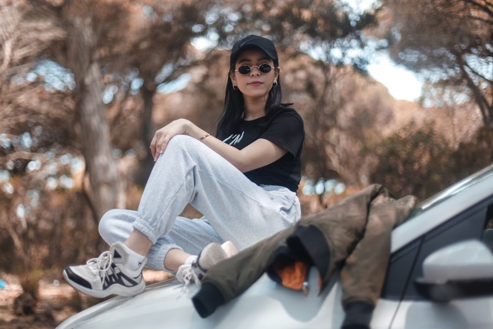 woman sitting on vehicle hood