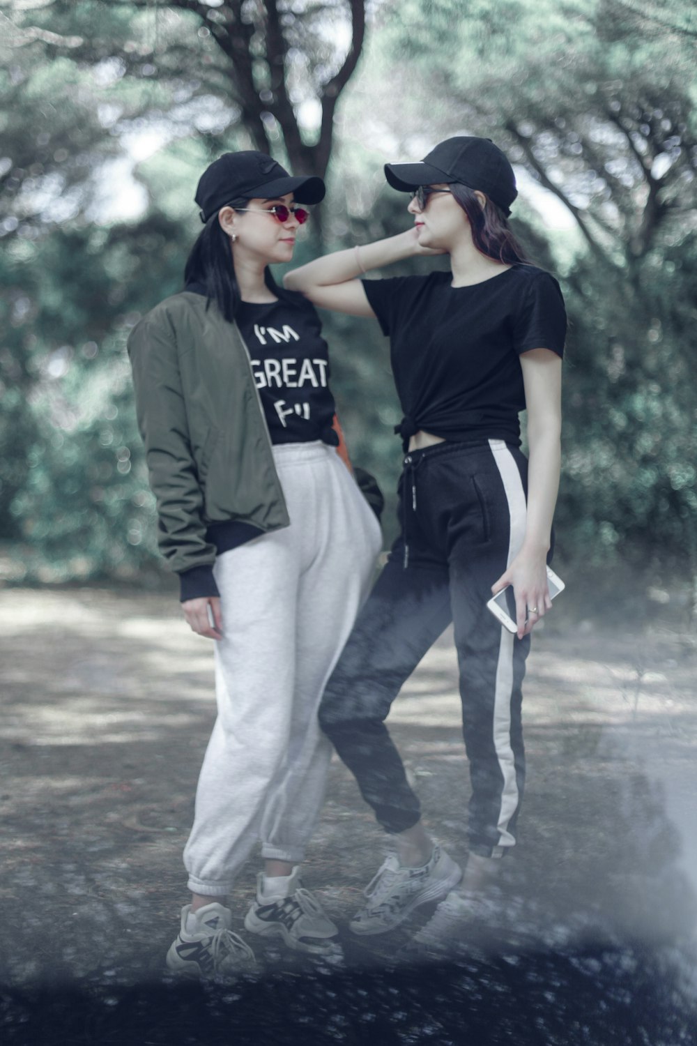 two women standing near trees