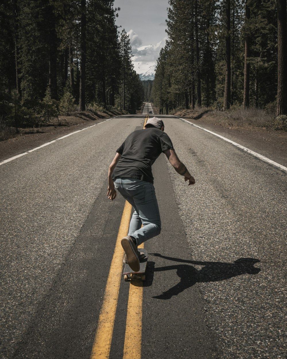 homme jouant à la planche à roulettes sur la route pendant la journée