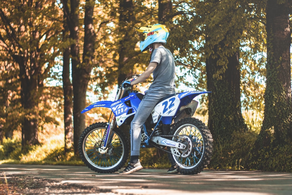 man riding on motorcycle beside trees