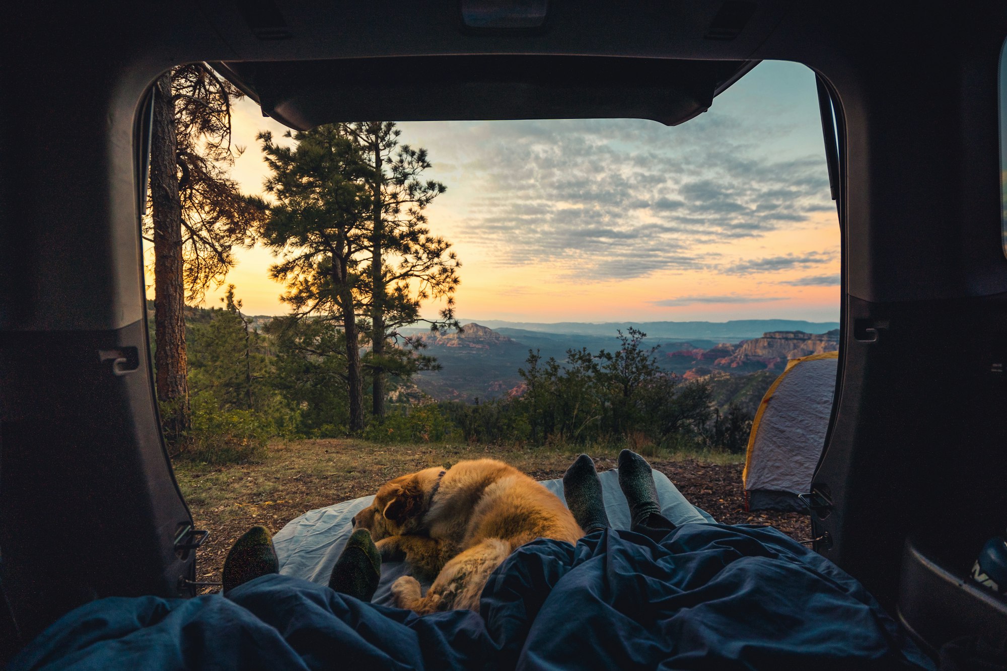 Enjoying sunrise while car camping over a cliff in Sedona, Arizona with girlfriend and dog.