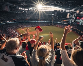 Cheering fans in school colors at a lively baseball game under bright stadium lights.
