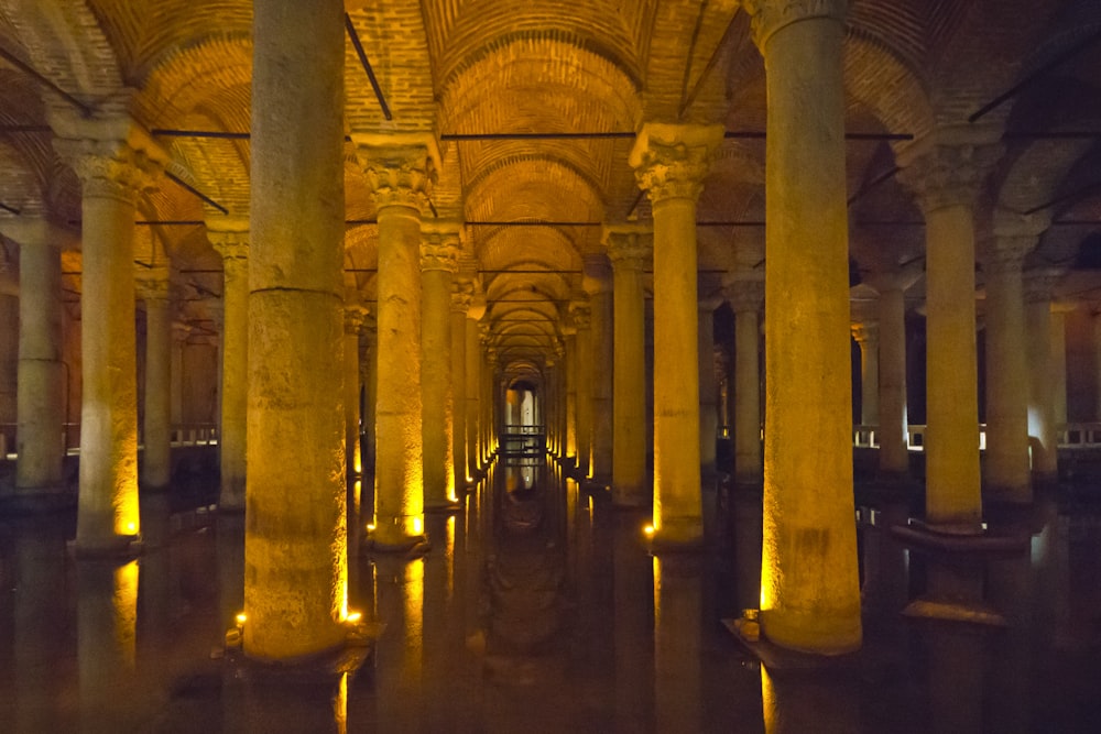 a long hallway with columns and lights in it