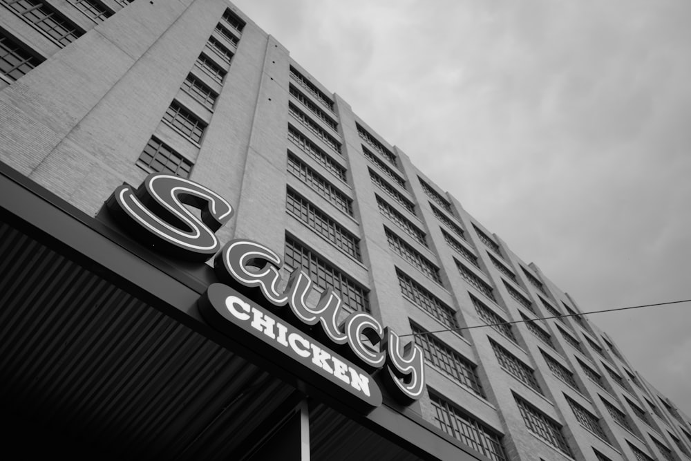 Saucy Chicken signage on building greyscale photo