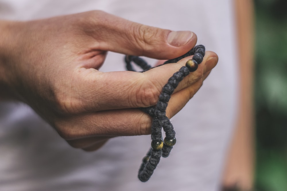 person holding black accessory