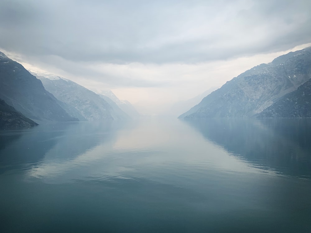 body of water between mountain during daytime