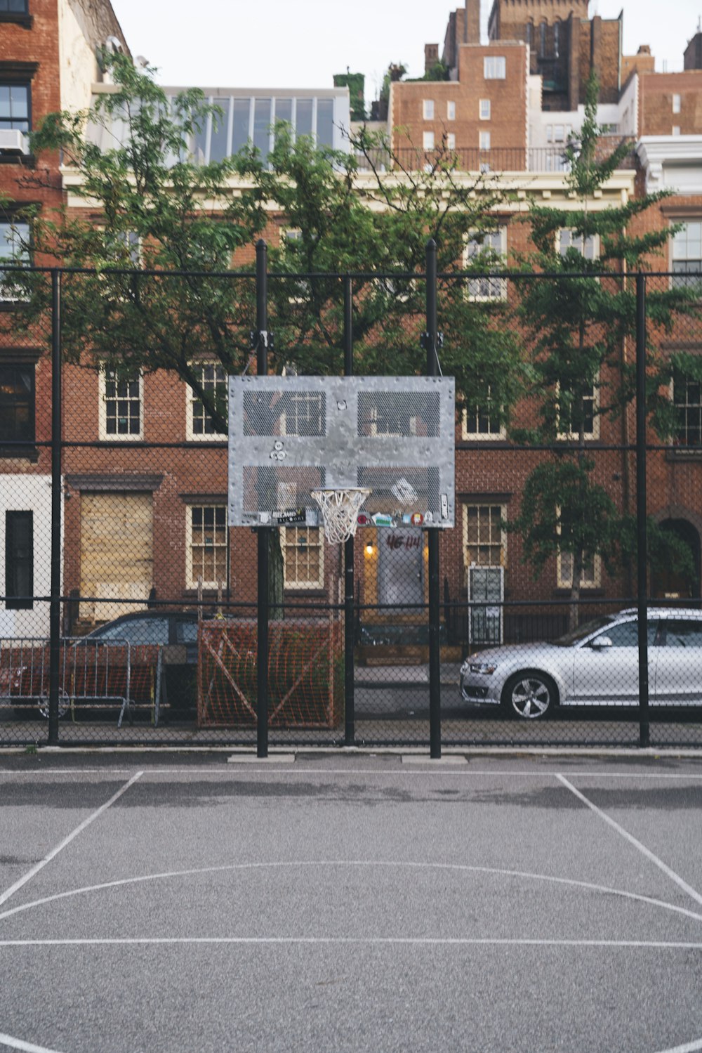 a basketball court in front of a brick building